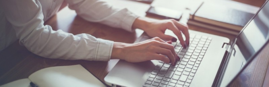 Woman working in home office hand on keyboard close up.
